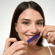 Purple teeth whitening strips neutralizing yellow stains on teeth