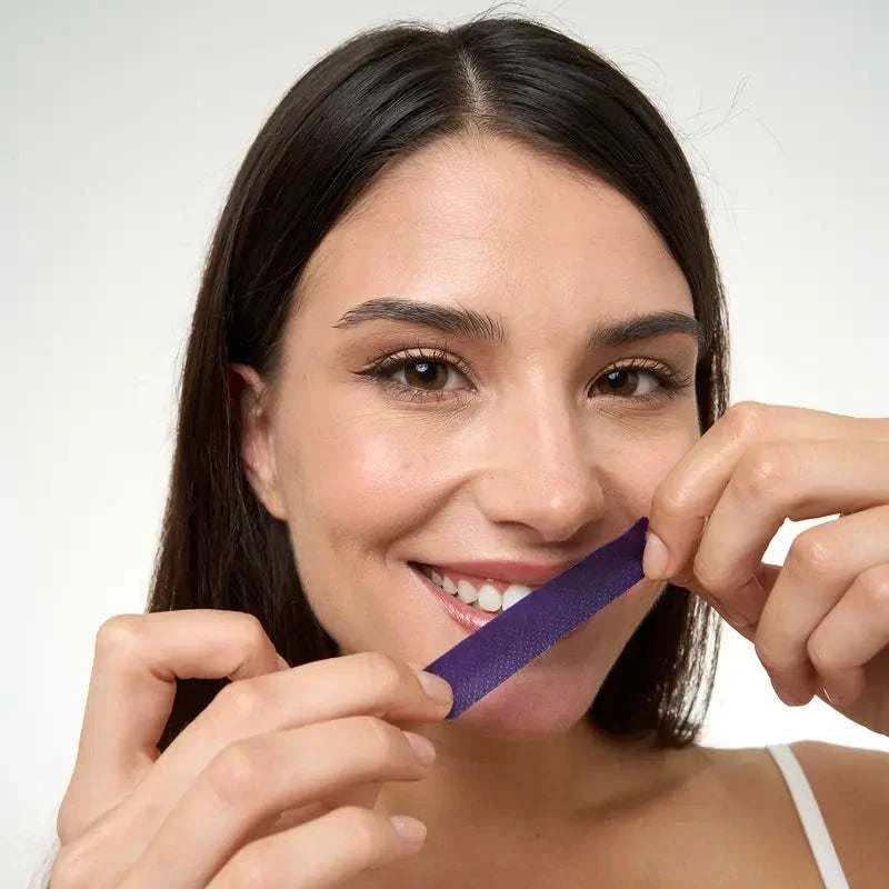 Purple teeth whitening strips neutralizing yellow stains on teeth